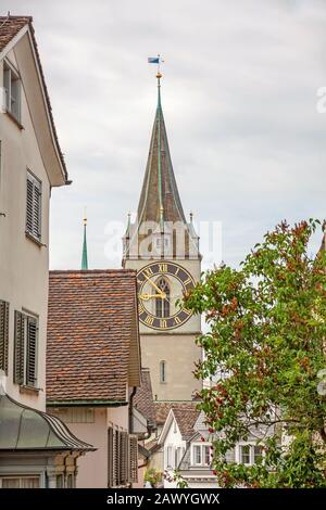 Zurich, Switzerland - June 10, 2017: Church Saint Peter, view through houses in downtown Zurich- Stock Photo