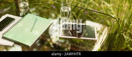 Digital tablet and eyeglasses on glass table Stock Photo