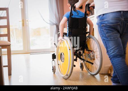 Boy pushing brother in wheelchair Stock Photo