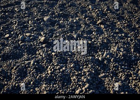 Volcanic rock pebbles on a beach. Suitable for a background. Stock Photo