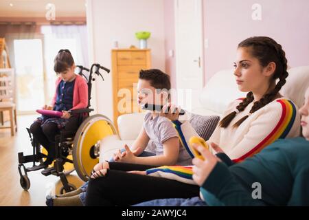 Family with Down Syndrome child watching TV in living room Stock Photo