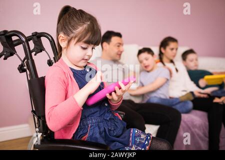 Girl using digital tablet in wheelchair Stock Photo