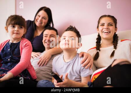 Happy family watching TV on sofa Stock Photo