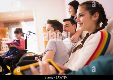 Happy family watching TV on living room sofa Stock Photo