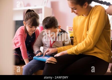 Brother and sisters using digital tablet Stock Photo