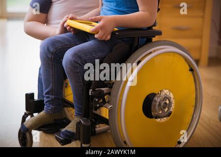 Boy in wheelchair using digital tablet Stock Photo