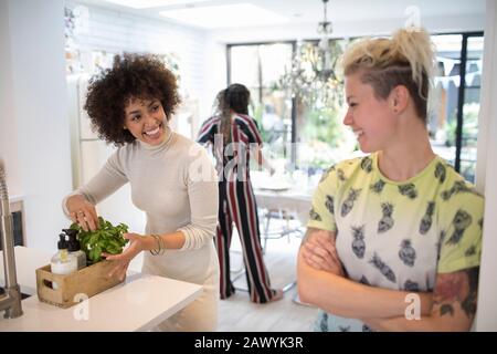 Happy young women talking in kitchen Stock Photo