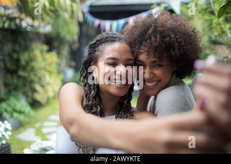 Happy young women friends taking selfie with camera phone Stock Photo