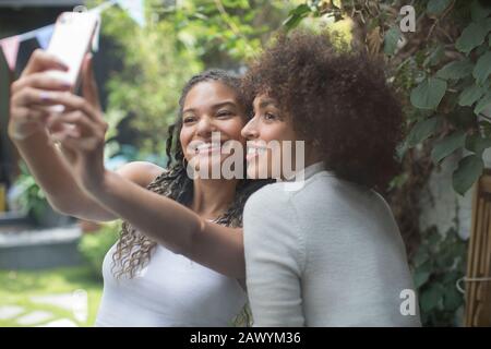 Beautiful young women friends taking selfie with camera phone Stock Photo