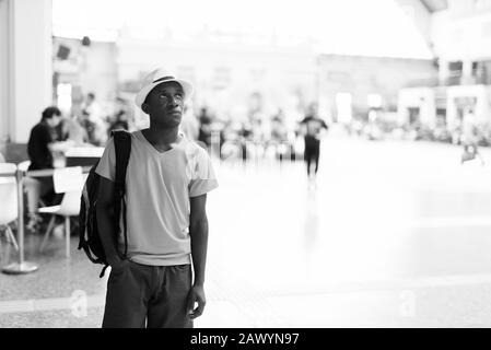 Young African tourist man thinking inside the railway station Stock Photo