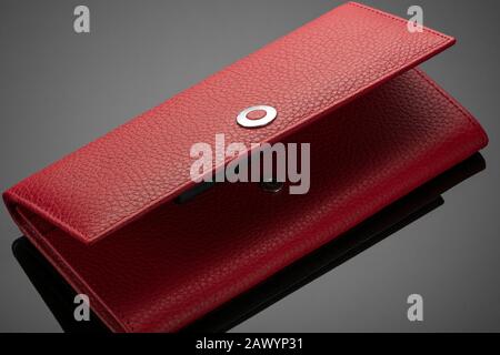 Fashionable red leather women's wallet on a dark background Stock Photo