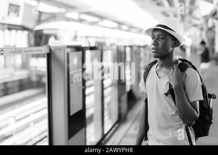 Young African tourist man thinking at skytrain station Stock Photo