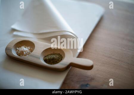 Gourmet salt and pepper in wooden tray on tissue paper Stock Photo