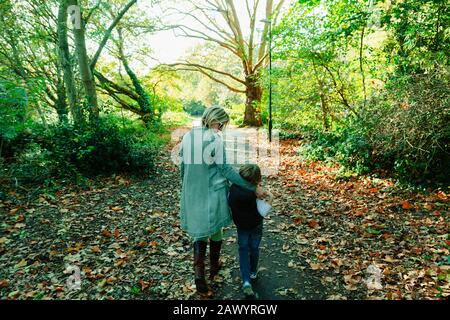 Mother and son walking in idyllic autumn park Stock Photo