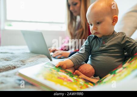 Cute curious baby girl reading picture book Stock Photo