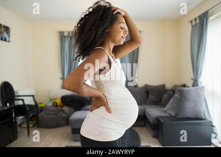 Tired young pregnant woman in living room Stock Photo
