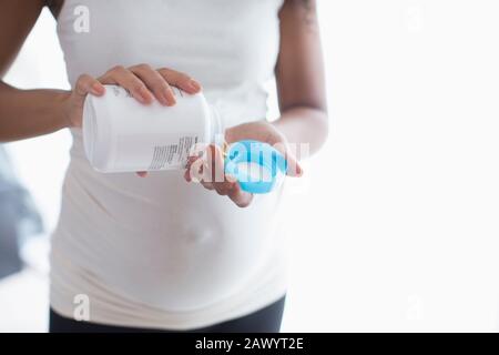 Young pregnant woman taking prenatal vitamins Stock Photo