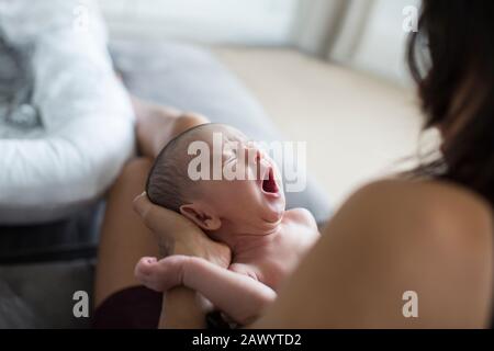 Mother holding crying newborn baby son Stock Photo