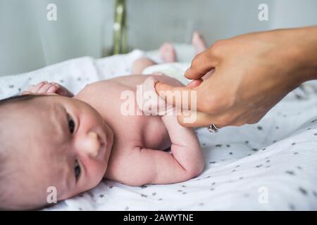 Close up mother holding hands with newborn baby son Stock Photo