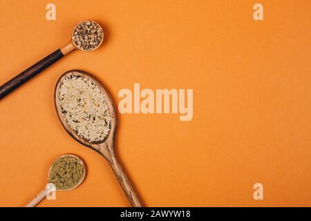 Different types of uses for hemp. Seeds, protein and powder in wooden spoons. Stock Photo