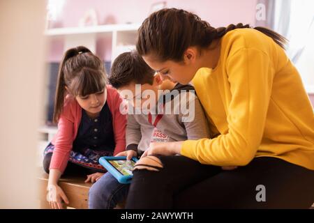 Sisters and brother with Down Syndrome using digital tablet Stock Photo