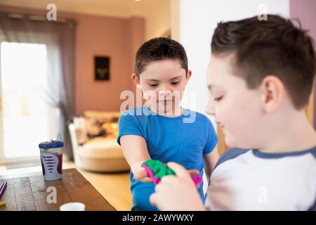 Boy with Down Syndrome and brother playing Stock Photo