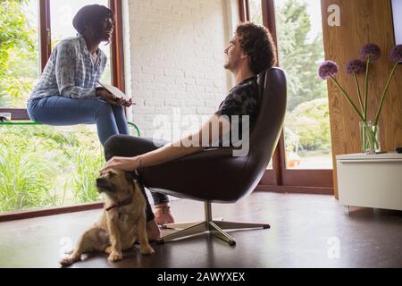 Happy young couple with dog using digital tablet in office Stock Photo