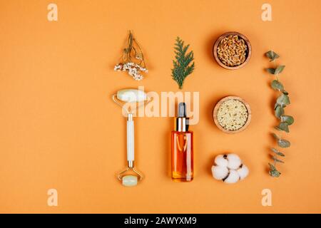 Modern apothecary with natural ingredients. Oil and cream made of herbs. Face roller for self-care. Flat lay style. Stock Photo