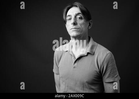 Mature handsome Italian man against gray background Stock Photo