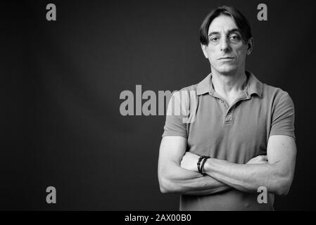 Mature handsome Italian man against gray background Stock Photo