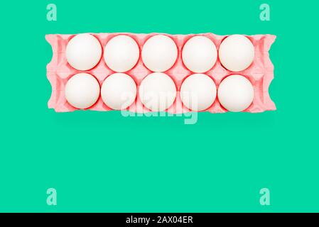 Chicken eggs in a red tray on a turquoise background. Advertising flyer, minimalism Stock Photo