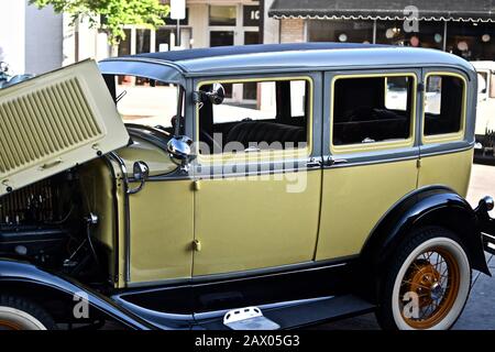 DOWNERS GROVE, UNITED STATES - Jun 07, 2019: A yellow vintage car parked in a parking lot Stock Photo