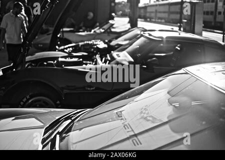 DOWNERS GROVE, UNITED STATES - Jun 07, 2019: A grayscale shot of different models of cars parked in a parking lot Stock Photo