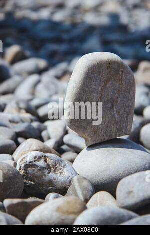 Vertical shot of a stone balanced on others during daytime Stock Photo