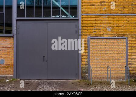 brick facade with an gate, yellow brick, facade, windows, industrial architecture, big door on a yellow brick wall Stock Photo