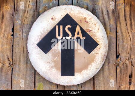 Vintage USA direction sign hanging on an old wooden wall