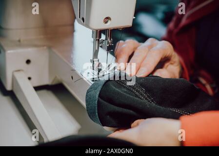 woman sews on the sewing machine Stock Photo