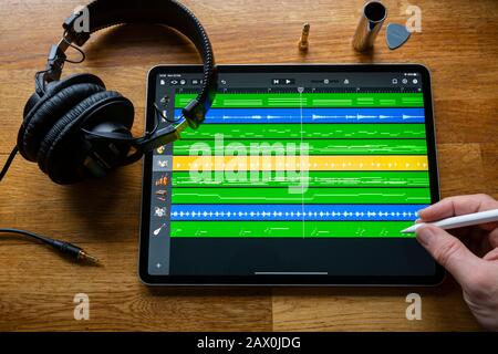 BATH, UK - FEBRUARY 10, 2020: Garage Band application being used to create and arrange music  on an Apple iPad Pro in a home studio environment. Stock Photo