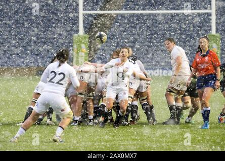 England's Claudia MacDonald passes the ball out to Katy Daley-Mclean as snow falls during the Women's Six Nations match at BT Murrayfield Stadium, Edinburgh. Stock Photo