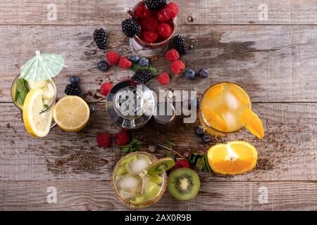 different kinds of fruit juices accompanied by a metal shaker on a wooden base. concept of healthy living Stock Photo