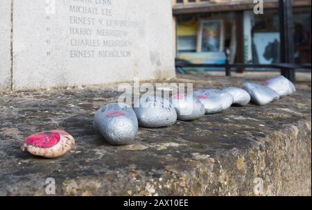 Remembrance stones by a war memorial, painted with poppies & messages, believed to be placed by Scouts at a war memorial in Arundel, West Sussex, UK. Stock Photo