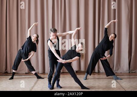 Professional contemporary dancers working on new dance moves in studio, horizontal shot Stock Photo