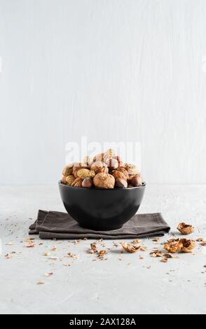 Peanuts and nuts in a bowl on a delicate background Stock Photo