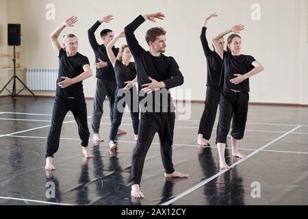 Group of male and female dancers learning new dance in rehearsal studio, horizontal shot Stock Photo