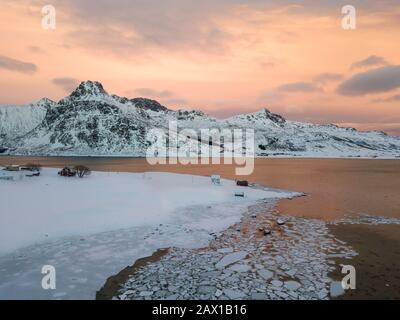 Aerial drone panoramic view. Beautiful sunset over the mountains and sea of the Lofoten Islands. Reine, Norway. Winter landscape with amazing colors. Stock Photo