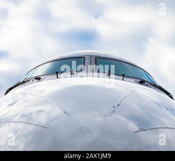 Cockpit of jet airplane against cloudy skies Stock Photo