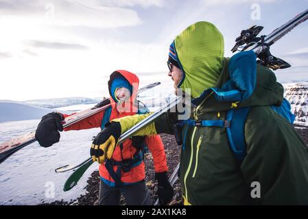 Woman and man laughing while walking with skis in Iceland Stock Photo