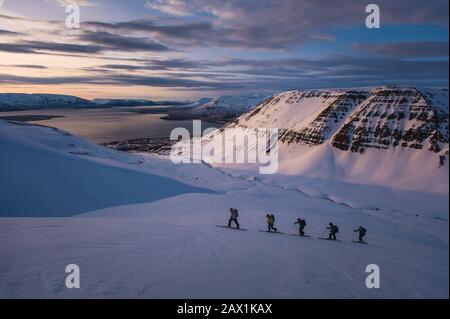 Group of people backcountry skiing at sunrise in Iceland Stock Photo