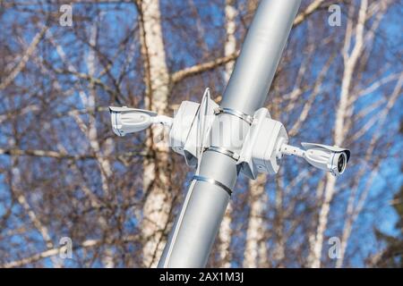 Security cameras hanging on the city park lantern. Stock Photo