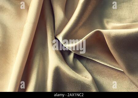 fabric wavy abstract gold background color close-up for design Stock Photo